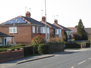 solar_house_geograph - Flux Solar Energy Detached house with rooftop solar panels, blue sky background